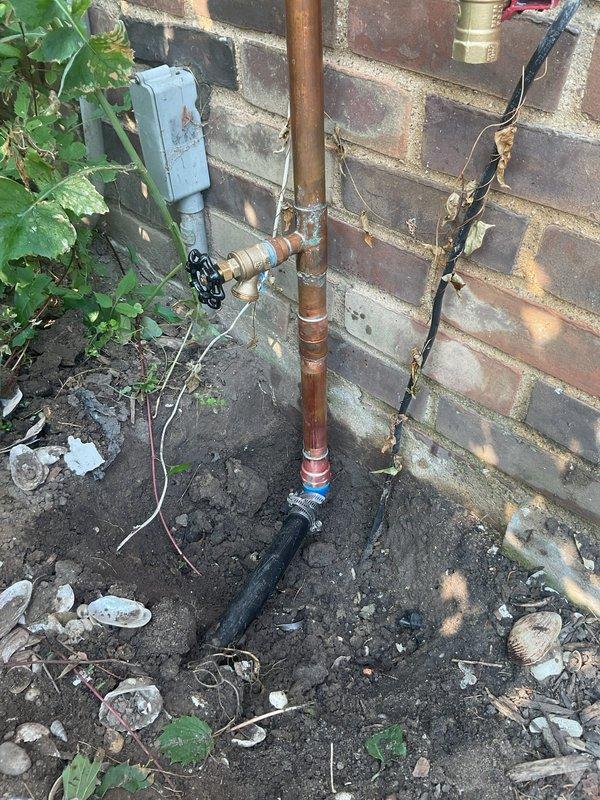 Responded to service call for cracked irrigation fitting on exterior copper plumbing assembly. Upon inspection, identified compromised plastic coupling connection on vertical supply line running along brick wall exterior. Replaced failed irrigation fitting and verified all connections were secure, including brass shutoff valve and hose bib assembly. System tested and confirmed operational with no leaks detected.