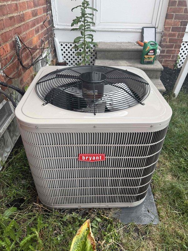 Completed comprehensive Gold AC Inspection and preventive maintenance on 15-year-old Bryant air conditioning system with components located in basement and backyard. Performed complete system evaluation including inspection of outdoor condenser unit positioned on concrete pad against brick wall, verified proper clearance from surrounding vegetation and structures, and confirmed unit is operating within normal parameters. Inspected condenser coils with horizontal fin configuration, checked fan operation and protective grille integrity, examined electrical connections at wall-mounted junction box, and verified refrigerant lines and conduit installations. Evaluated indoor components in basement including air handler, evaporator coil, and associated ductwork. Cleaned condenser coils to remove debris and ensure optimal heat transfer efficiency, checked refrigerant pressures and temperatures to confirm proper system charge, tested capacitor performance and electrical connections for safety a