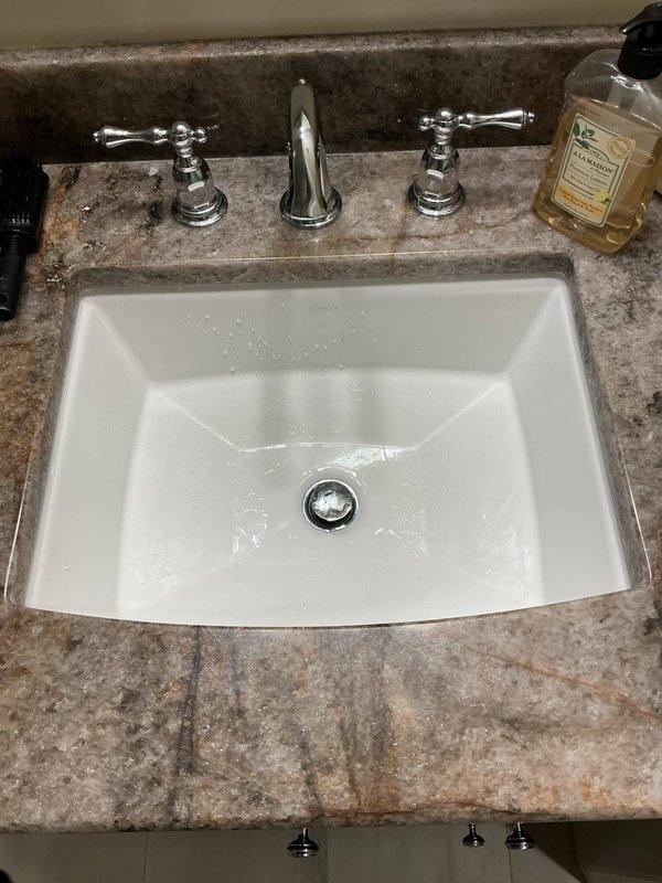 Responded to third floor bathroom sink with stuck drain stopper in down position. Successfully removed and freed the jammed pop-up drain assembly from the undermount porcelain basin. Inspected pivot rod mechanism and clevis connection for damage or excessive buildup causing the malfunction. Cleared minor debris from drain assembly, cleaned stopper seal, and reinstalled components. Tested stopper operation through multiple open and close cycles to verify smooth function. Confirmed proper drainage flow and seal when closed. Left sink operational with fully functioning pop-up drain mechanism.