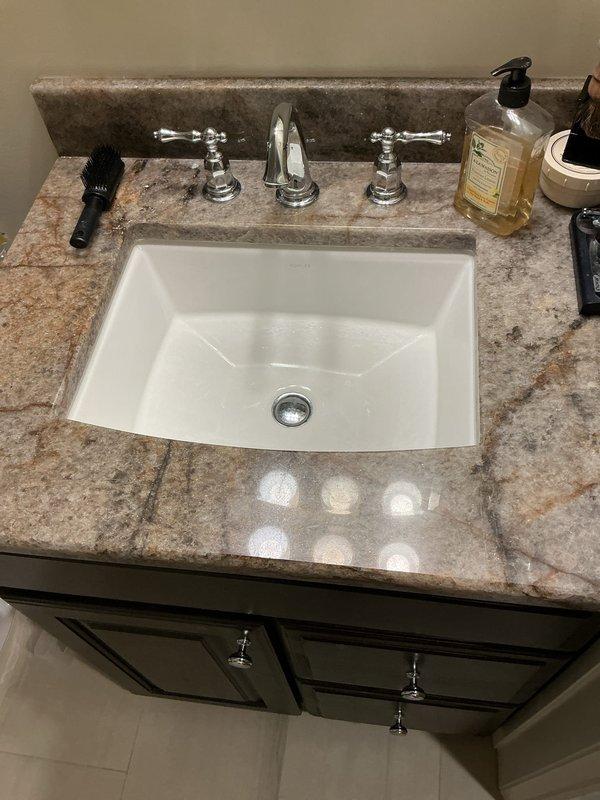 Responded to third floor bathroom sink with stuck drain stopper in down position. Successfully removed and freed the jammed pop-up drain assembly from the undermount porcelain basin. Inspected pivot rod mechanism and clevis connection for damage or excessive buildup causing the malfunction. Cleared minor debris from drain assembly, cleaned stopper seal, and reinstalled components. Tested stopper operation through multiple open and close cycles to verify smooth function. Confirmed proper drainage flow and seal when closed. Left sink operational with fully functioning pop-up drain mechanism.