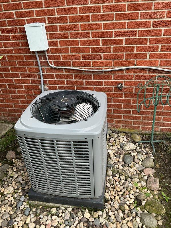 Completed HVAC system replacement estimate for a small residential property under 1500 square feet requiring both heating and cooling equipment. Assessed existing outdoor air conditioning condenser unit positioned against exterior brick wall with refrigerant lines running to disconnect box, and evaluated basement-located heating system utilizing natural gas or propane as energy source. Documented current equipment configuration and provided replacement recommendations for complete dual-fuel HVAC system upgrade.