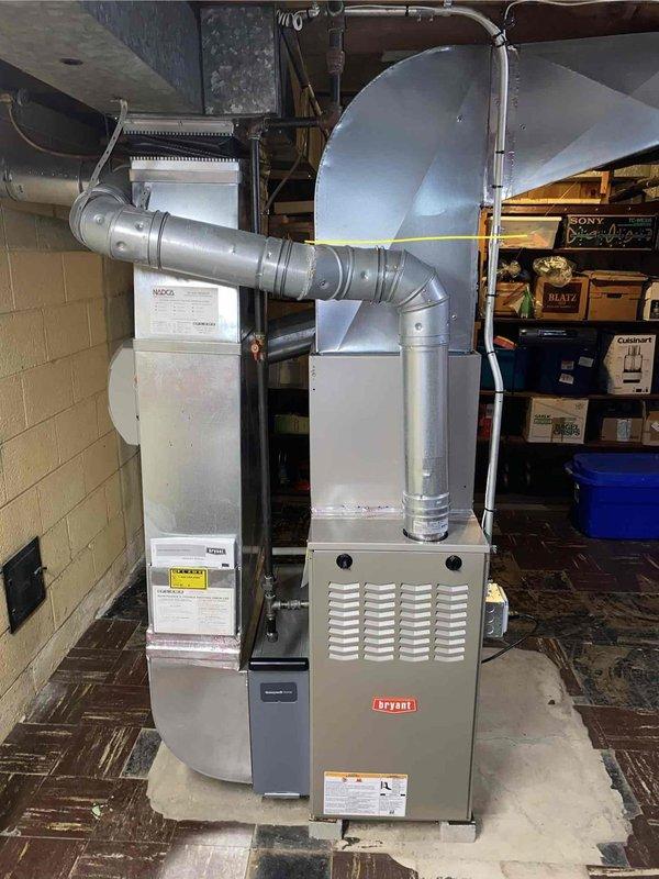 Completed comprehensive gold-level air conditioning inspection on 14+ year old single-unit system with basement-located air handler. Performed thorough evaluation of Bryant furnace and connected HVAC components, including ductwork distribution system, auxiliary humidification equipment, and air handling assembly. Documented existing system configuration with metallic ductwork routing through ceiling joists and assessed overall equipment condition for replacement estimate purposes.