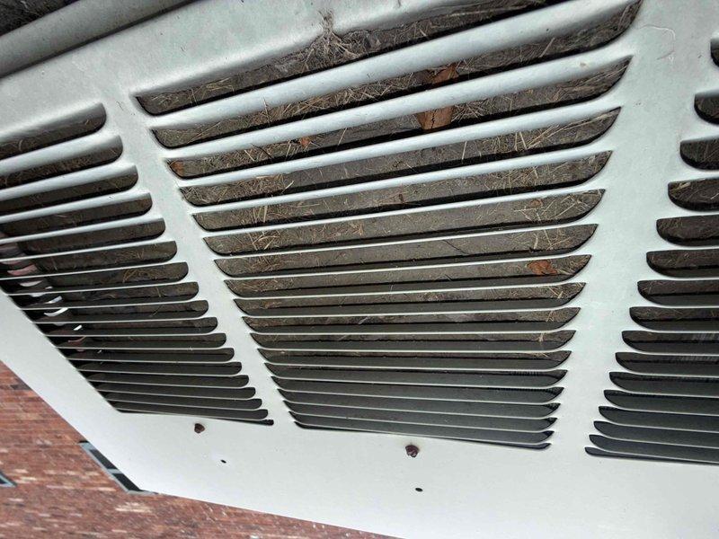 Responded to no cooling complaint with system blowing warm air and thermostat stuck at 82°F. Upon arrival, found outdoor unit running continuously for 24 hours. Inspection revealed severely restricted airflow due to heavily clogged return air vent with significant accumulation of dust, debris, and pet hair blocking air intake. Additionally, discovered condensate drain line failure in basement resulting in water leakage on floor near equipment. Cleaned return air grill thoroughly to restore proper airflow. Cleared condensate drain line blockage and repositioned drain tube to prevent future water accumulation. Verified system operation with adequate airflow restored and proper condensate drainage functioning. System cooling restored to normal operation with thermostat responding appropriately. Documented conditions with photos and recommended regular filter maintenance to prevent future airflow restrictions.