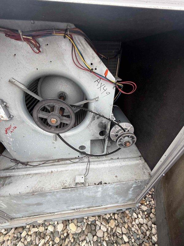 Responded to no cooling complaint on commercial rooftop unit RTU 5. Accessed roof-mounted equipment, inspected blower assembly and motor drive system, verified belt condition and tension on centrifugal fan. Documented unit configuration and operational status with AX42 designation, checked wiring connections and motor mounting. Unit restored to proper cooling operation.