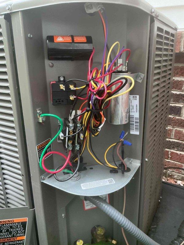 Responded to callback for outdoor AC unit experiencing loud noise at startup following series of power outages. Unit is approximately one year old and located in basement area. Upon inspection, installed hard start kit to address intermittent noise and cooling issues related to compressor startup after electrical disturbances. Verified all electrical connections at contactor and capacitor, ensured proper wire routing and secure terminations. Cycled unit multiple times to confirm reduced startup noise and proper cooling operation. Unit now operating within normal parameters with improved compressor startup performance.