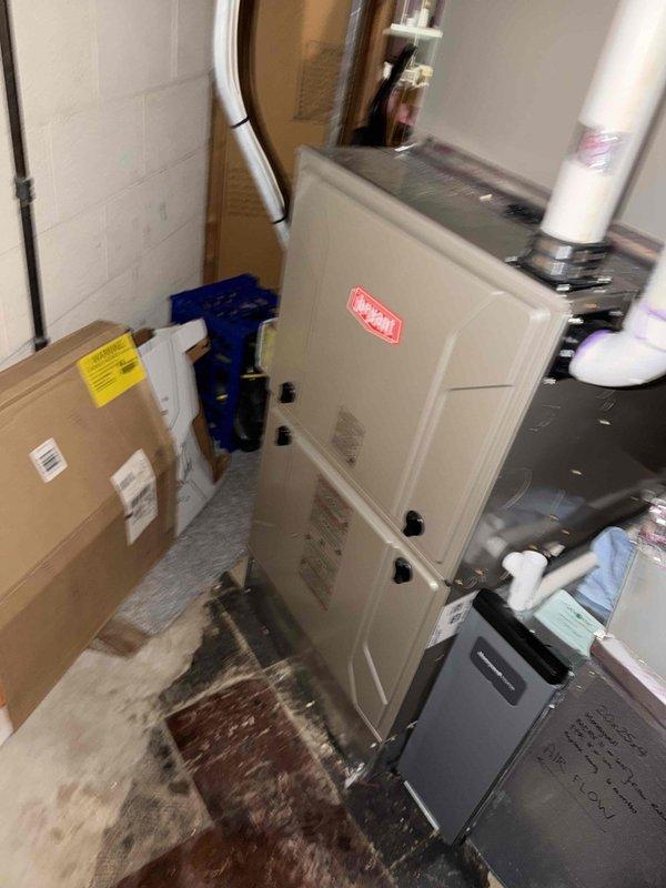 Responded to service call for water leak at basement HVAC system. Upon inspection of 10-year-old furnace and air conditioning unit, identified source of leak and assessed condensate drainage system including PVC piping configuration. Examined air handler unit, refrigerant lines, and associated plumbing connections to determine origin of moisture issue. Documented equipment condition with photographic evidence showing HVAC installation, ductwork, copper refrigerant lines with insulation, and condensate management components for further evaluation and repair recommendations.