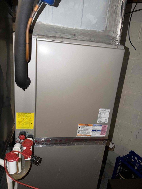 Responded to service call for water leak at basement HVAC system. Upon inspection of 10-year-old furnace and air conditioning unit, identified source of leak and assessed condensate drainage system including PVC piping configuration. Examined air handler unit, refrigerant lines, and associated plumbing connections to determine origin of moisture issue. Documented equipment condition with photographic evidence showing HVAC installation, ductwork, copper refrigerant lines with insulation, and condensate management components for further evaluation and repair recommendations.