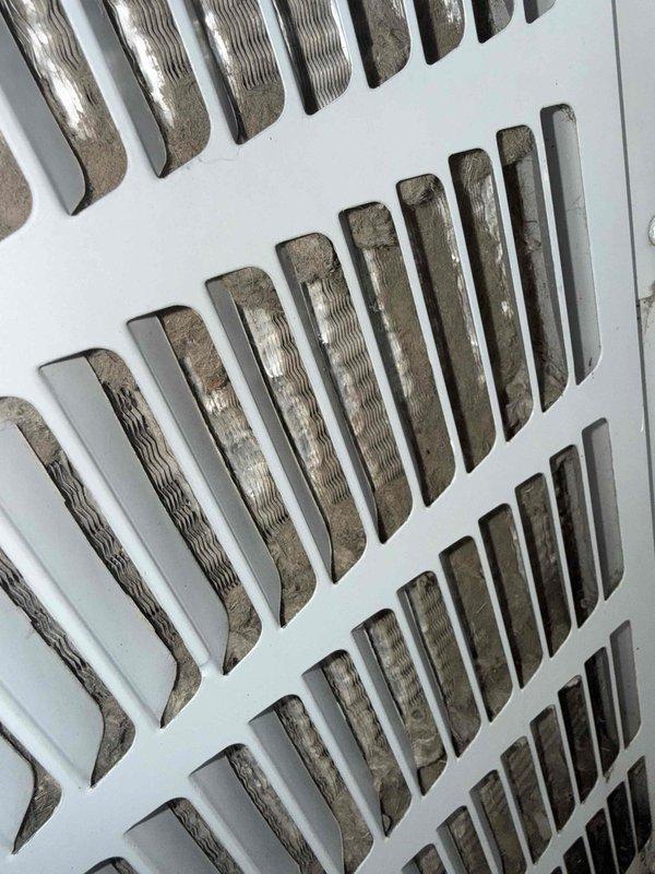 Responded to no cooling complaint on 19-year-old outdoor air conditioning unit. Upon arrival, performed visual inspection of system components and documented current condition of air handling equipment. Observed significant dust and debris accumulation on return air grille, indicating restricted airflow and lack of recent maintenance. Photographed ventilation components showing buildup on louvered surfaces. Due to age of equipment and extent of service required, appointment was rescheduled for comprehensive diagnostic evaluation and necessary repairs to restore cooling functionality.