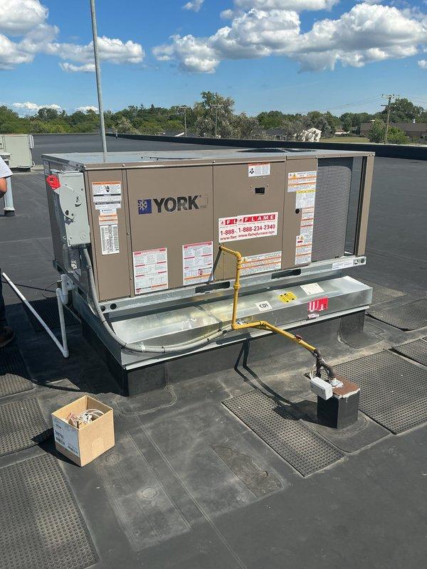 Completed full RTU replacement on unit #41 including removal and recycling of existing equipment. Installed new York packaged rooftop unit using 28-ton crane for lifting and positioning on factory-direct curb at front shipping area. Configured economizer controls, upgraded electrical disconnect, and installed White-Rodgers 1F95-0680 thermostat. Secured all required city permits and inspections. Unit is now operational with 10-year heat exchanger warranty, 5-year compressor warranty, and 2-year parts and labor coverage.