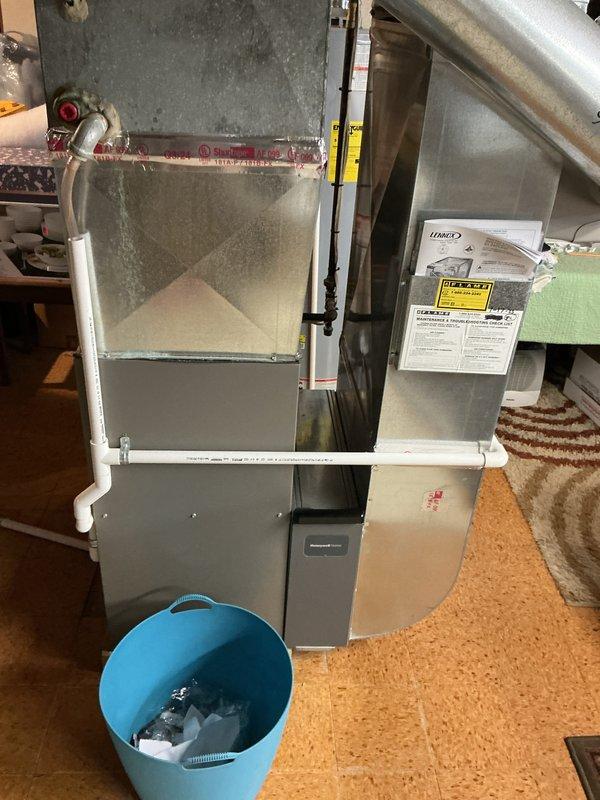 Provided estimate for complete HVAC system replacement including outdoor AC condenser unit and basement-located natural gas furnace. Existing 15-year-old system is non-operational and requires full replacement. Evaluated current installation with metal ductwork, PVC condensate drainage, and outdoor cylindrical condenser unit with protective wire grille positioned on exterior side yard.
