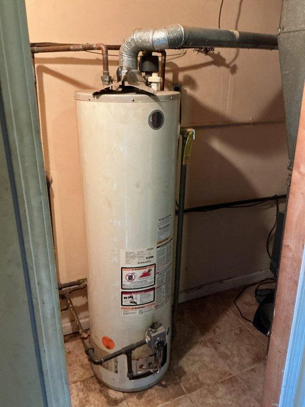 Installed a 40-gallon tank-style water heater in residential utility closet. Connected hot and cold water copper supply lines to unit, installed aluminum exhaust vent ducting to existing black insulated vent pipe, and verified proper clearances from adjacent HVAC equipment. All connections tested and operational upon completion.
