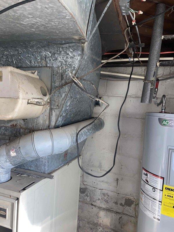 Conducted comprehensive site assessment for complete HVAC system replacement in residential property. Evaluated existing 27-year-old furnace and current air conditioning system for replacement specifications. Inspected basement mechanical room layout, including existing ductwork configuration, electrical service capacity, condensate drainage routing, and available clearances for new equipment installation. Documented existing silver insulated supply ductwork, PVC condensate lines, and electrical wiring infrastructure. Assessed concrete block foundation conditions and identified moisture concerns along lower wall sections that may require consideration during installation. Evaluated water heater proximity and spatial requirements for proper equipment placement and code-compliant clearances. Prepared detailed replacement estimate including equipment specifications, installation requirements, and necessary modifications to existing infrastructure to accommodate new high-efficiency heating
