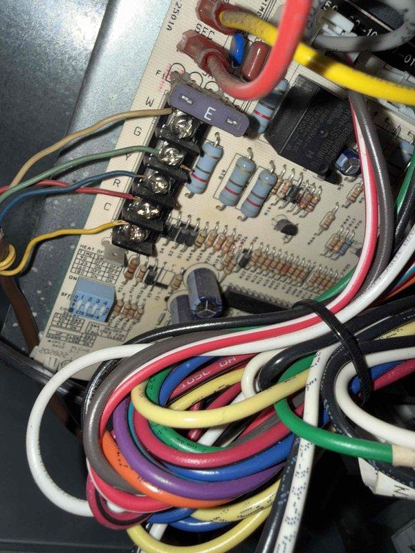 Responded to no cooling call on 2001 Rheem forced air system located in basement. Customer reported air conditioning failure after attempting to install Nest thermostat using only 3 of 5 available wires, then reinstalling original thermostat without success. Upon arrival, inspected control board wiring and thermostat connections at unit. Verified proper wire terminations at furnace control board terminal strip and traced low voltage circuit. Identified improper thermostat wire connections resulting from DIY installation attempt. Reconnected thermostat wiring to appropriate terminals per manufacturer specifications, ensuring all five conductors were properly landed. Restored power to unit and verified 24VAC control voltage present. Cycled system through heating and cooling modes to confirm proper operation of compressor, blower motor, and reversing valve. System returned to normal operation with no further issues observed.