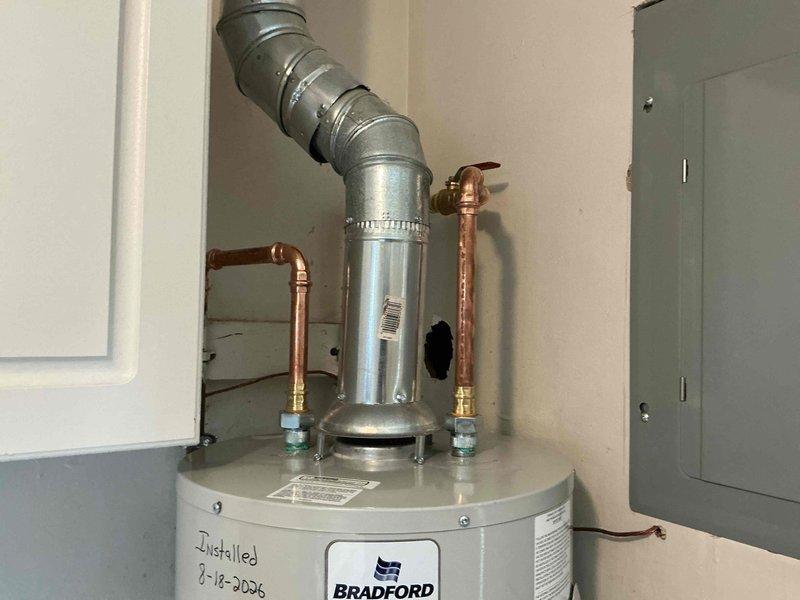 Installed a new 40-gallon Bradford White slim profile water heater with a 20-inch drain pan in residential utility room. Relocated gas line to accommodate new unit positioning, connected copper supply lines with appropriate shut-off valves and fittings, and verified all plumbing connections for proper operation. All work completed to code specifications with safety valves and expansion tank properly installed.