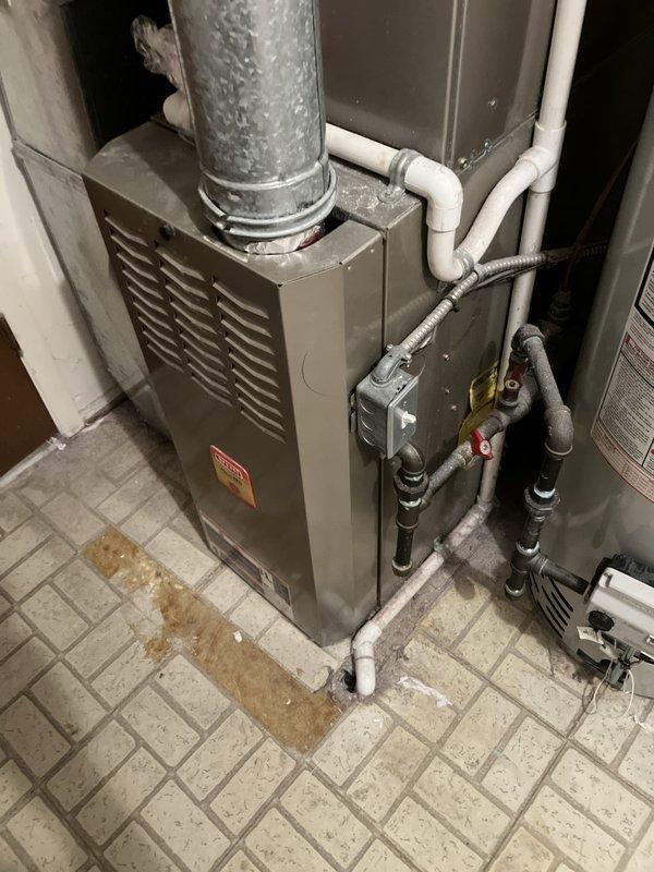 Performed comprehensive inspection of 20-year-old residential HVAC system located in basement. Identified cracked heat exchanger in gas furnace, presenting safety concern requiring immediate attention. Evaluated air conditioning system showing low refrigerant levels and diminished cooling capacity. Assessed overall system condition, noting significant age-related deterioration on equipment labels and components. Documented gas valve assembly, ductwork connections, and condensate drain lines. Provided full system replacement estimate due to critical heat exchanger failure and age of equipment beyond serviceable life expectancy.