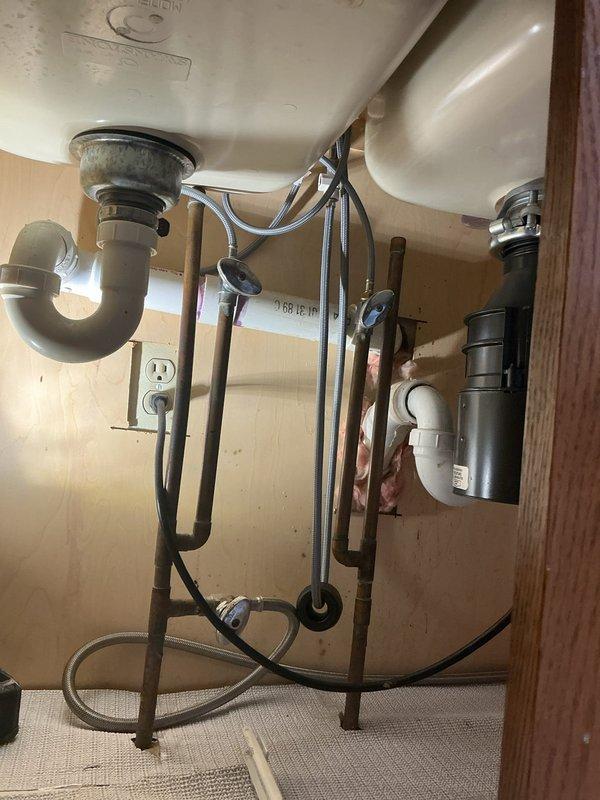 Installed customer-supplied chrome pull-out kitchen faucet with matching soap dispenser on double-basin undermount sink with granite countertop. Verified all supply line connections, tested faucet operation and spray function, confirmed proper drainage, and ensured no leaks at mounting points or under-cabinet connections.