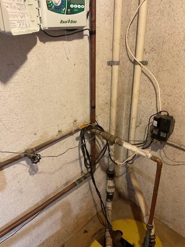 Responded to a non-draining sink that had been previously snaked 20 feet with no lasting results. Upon inspection, identified the issue as a sump pump drainage system with potential backup concerns in the basement utility area. Assessed the copper piping configuration, sump pump basin, and discharge lines connected to the drainage system. Cleared the obstruction and verified proper water flow through the sump pump discharge to restore full drainage functionality.