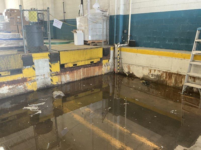 Responded to commercial facility experiencing complete flooding in dock area due to failed sump pump system. Upon arrival, found extensive standing water throughout the loading dock space with significant accumulation and debris. Assessed non-operational sump pump unit and determined pump failure had caused backup, resulting in substantial water damage to concrete block walls, industrial equipment, and floor surfaces. Restored pump functionality and initiated water removal process using industrial extraction equipment. Verified proper pump operation and drainage capability before clearing the service area.