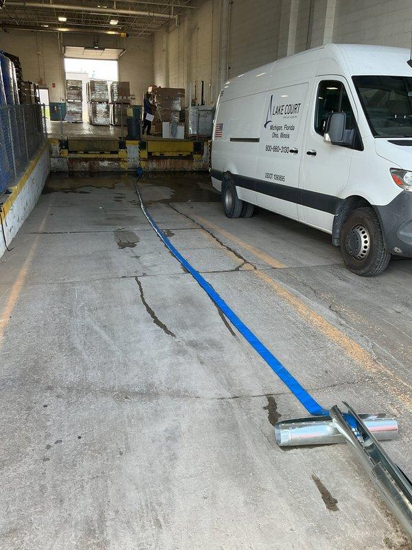 Responded to commercial facility experiencing complete flooding in dock area due to failed sump pump system. Upon arrival, found extensive standing water throughout the loading dock space with significant accumulation and debris. Assessed non-operational sump pump unit and determined pump failure had caused backup, resulting in substantial water damage to concrete block walls, industrial equipment, and floor surfaces. Restored pump functionality and initiated water removal process using industrial extraction equipment. Verified proper pump operation and drainage capability before clearing the service area.