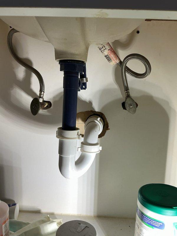 Completed comprehensive whole home plumbing inspection for new homeowner. Inspected all accessible plumbing fixtures, supply lines, drain assemblies, and shut-off valves throughout the residence. Identified non-functional drain stopper mechanism in bathroom sink and noted excessive noise during bathtub water flow, likely caused by inadequate venting or drain line restrictions. Documented bathroom plumbing configuration including under-sink P-trap assembly with plastic tailpiece and PVC connections, braided stainless steel supply lines, and toilet water supply with brass angle stop valve. Observed evidence of previous water exposure on bathroom flooring near toilet shut-off valve area with visible staining on travertine tile surface, indicating potential historical leak or condensation issue. Photographed relevant plumbing components for documentation and customer reference. Provided detailed quote for necessary repairs including drain stopper replacement and investigation of bathtub dr