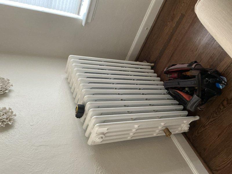 Responded to service call for leaking radiator in residential property. Upon inspection, discovered severe rust and corrosion on copper piping connected to boiler radiator system located in basement, with active water leak causing damage to equipment. Performed diagnostic evaluation of heating system components, identified compromised pipe integrity and deteriorated radiator connections as source of leak. Documented equipment condition through photographic evidence showing extensive corrosion on copper lines and aging radiator unit. Advised homeowner of findings and provided recommendations for necessary repairs to prevent further water damage and restore proper heating system operation.