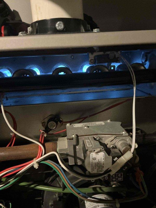 Completed comprehensive tune-up and inspection on five HVAC units including gas furnace, boiler, central air conditioning system, and two roof-mounted mini-split condensers. Performed full system diagnostics on furnace with inspection of gas valve assembly, burner operation, and pilot flame performance; all components operating within manufacturer specifications. Verified R410A refrigerant charge levels, electrical connections, and pressure readings on air conditioning equipment per nameplate specifications (model 123ANA042, serial 1418E28895). Inspected both mini-split systems requiring roof access with tall ladder; confirmed proper operation of all condensing units and indoor air handlers located in basement. All equipment aged 8-10+ years showing normal wear; burner flames burning clean and blue, gas connections secure, and electrical components functioning properly with no immediate service needs identified.