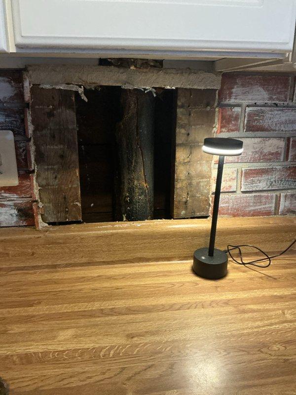 Responded to reported stack pipe leak in residential property. Upon investigation, accessed ceiling cavity through drop ceiling system in kitchen area and inspected plumbing stack penetration. Found active leak at stack pipe connection point with evidence of water intrusion causing damage to surrounding structural components. Further inspection revealed water damage extending to fireplace area with deterioration of wooden framing members and visible moisture staining on exposed materials. Documented conditions with photographic evidence showing compromised ceiling tiles, exposed piping in ceiling cavity, and water-damaged fireplace framing with signs of prolonged moisture exposure. Identified source of leak at defective stack pipe joint requiring repair or replacement to prevent further water damage to structure.