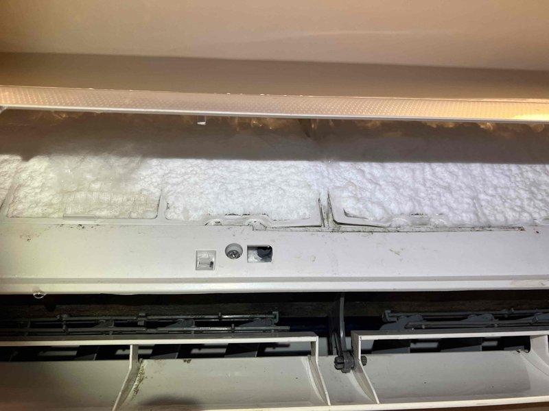 Completed callback diagnostic on approximately 10-year-old mini split system serving wine cellar with reported ice buildup and possible 20-amp cartridge failure. Unit had been powered down 24 hours prior to appointment as recommended to allow ice to thaw. Upon arrival, performed visual inspection of indoor evaporator unit with cover removed, revealing insulation, fan assembly, and internal components. System still in thawing process, preventing complete diagnostic testing of refrigerant circuit and electrical components. Documented current condition with photos showing evaporator coil assembly and exterior condensing unit installation. Unable to complete full diagnostic evaluation due to incomplete thawing of ice accumulation on evaporator coil. Callback appointment required to finalize diagnostic testing once unit has fully thawed and to determine root cause of ice formation, verify refrigerant charge levels, check airflow restrictions, and test electrical components including suspect