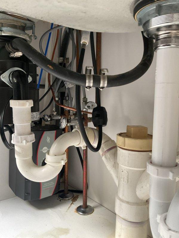 Completed installation of stainless steel double-basin kitchen sink with modern pull-down faucet in brushed nickel finish and coordinating soap dispenser. Connected all drain assemblies including garbage disposal unit with proper PVC trap configuration, verified all supply line connections, and tested system for proper drainage and leak-free operation.