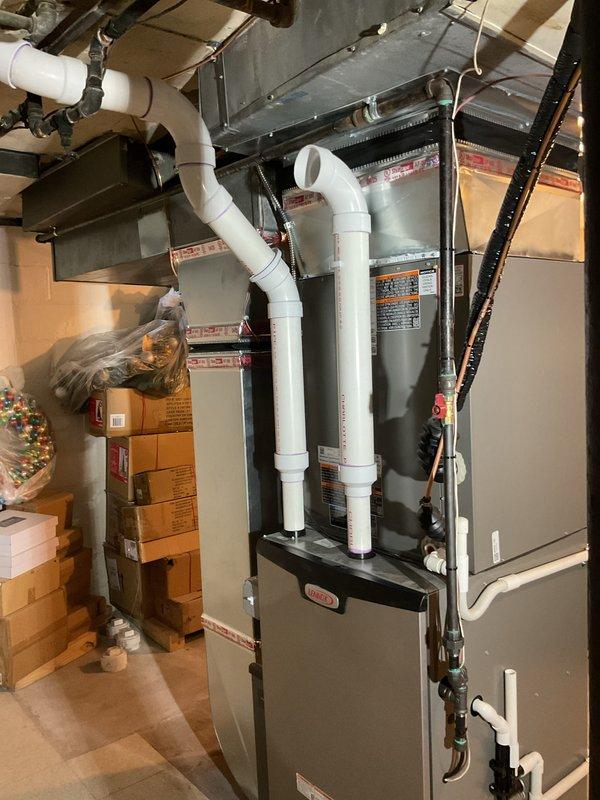 Completed full HVAC system installation including 135,000 BTU Lennox furnace and 5-ton air conditioning unit in basement mechanical room. Installed chimney liner for proper venting, ran white PVC intake and exhaust piping from furnace, and connected all ductwork including high velocity package system. Installed thermostat control (S40), performed system flush, and reconnected all utilities including gas and electrical connections. Applied for mechanical permit and coordinated utility rebate paperwork. All equipment tested, operational, and left in proper working condition with customer walkthrough completed.