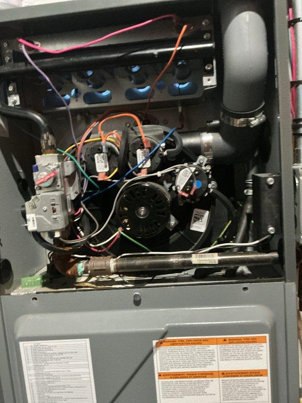 Completed comprehensive Gold membership inspection on 8-year-old HVAC system consisting of basement-located furnace with air handler and outdoor Daikin condensing unit. Began service with exterior AC unit per customer request due to pets, performing visual inspection of condenser cabinet, fan assembly, refrigerant line connections, and electrical conduit routing. Unit showed good overall condition with minimal weathering on cabinet exterior and properly secured mounting platform with PVC support structure. Proceeded to interior furnace inspection after exterior work completed, removing access panel to examine blower motor assembly, electrical connections, capacitors, and control wiring. Verified proper wire terminations at terminal block with color-coded connections intact, inspected blower motor and associated electrical components for signs of wear or damage, and examined refrigerant accumulator and associated piping. All internal components showed normal operating condition with no 