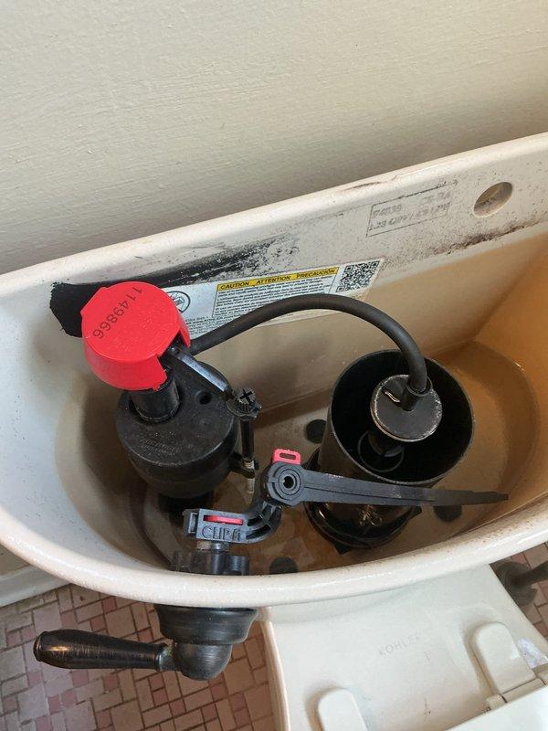 Responded to main floor bathroom plumbing issues in a sixty-year-old home where toilet was not filling properly after flushing. Inspected toilet tank components and identified fill valve malfunction preventing proper water refill. Examined fill valve assembly with red EASYSET cap, flush valve mechanism with rubber flapper, and overflow tube system. Verified water supply line and shut-off valve operation. Adjusted fill valve settings and tested flush cycle to restore proper tank refilling function. Also addressed bathtub diverter issue preventing proper switching from tub spout to shower head operation.