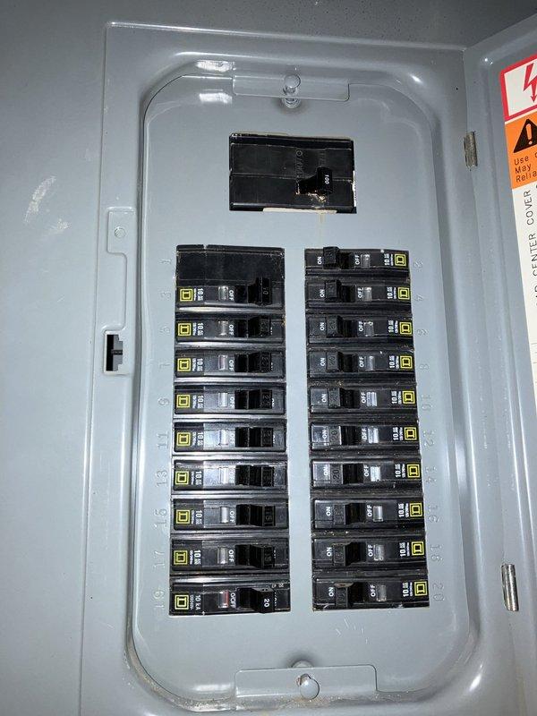Responded to service call for AC unit leaking inside the house with a 10-year-old system located in the basement. Upon inspection, discovered the system had low refrigerant charge and identified a cracked eyelet on the heat exchanger. Documented existing electrical panel configuration and outdoor condenser unit condition with photographs for estimate purposes.