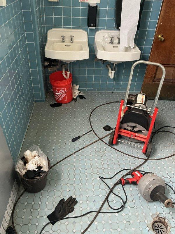 Responded to commercial plumbing service call regarding a baptismal pool heating issue. Upon inspection, accessed plumbing connections behind wall-mounted sinks in tiled bathroom facility to diagnose heating system malfunction. Performed drain cleaning and maintenance procedures using professional auger equipment on dual sink configuration. Exposed wall cavity to access baptismal pool supply lines and heating connections, identified and resolved circulation issues affecting water temperature control. Completed necessary repairs to restore proper heating function to baptismal pool plumbing system.