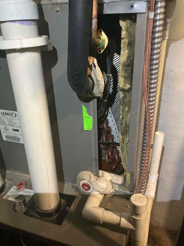 Responded to water leak complaint at basement furnace location. Upon inspection, discovered evaporator coil heavily contaminated with biological growth and mold, causing condensate drainage issues and water accumulation at both top and bottom of unit. The extensive microbial contamination on coil fins and copper refrigerant lines was restricting airflow and preventing proper condensate drainage through the PVC drain system. Documented conditions with photos showing the severity of contamination on the evaporator coil assembly and verified outdoor condenser unit condition. Recommended complete evaporator coil cleaning or replacement along with condensate drain line servicing to resolve water leak issue and restore proper system operation.