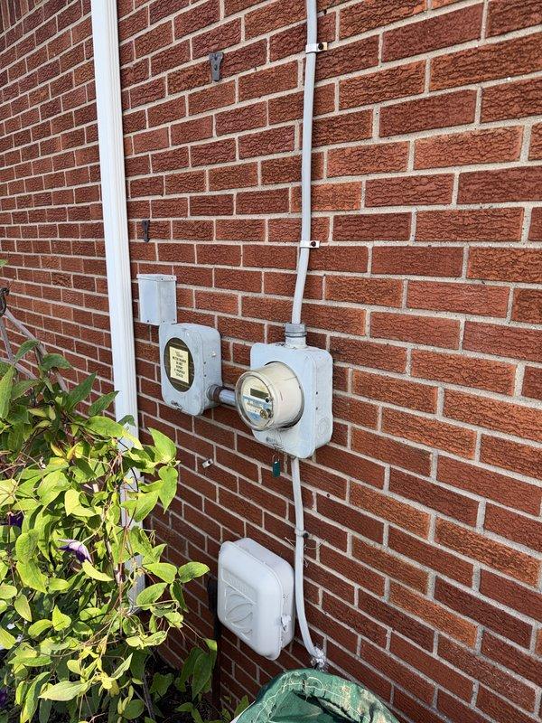 Completed full HVAC system installation including 70,000 BTU furnace, 2-ton air conditioning unit with rear placement, humidifier, and Sensi thermostat. Performed electrical reconnection work, installed new breaker panel circuits for equipment, and mounted exterior disconnect and meter connections on brick exterior wall. Mechanical and electrical permits were obtained, and system qualifies for utility rebates upon completion.