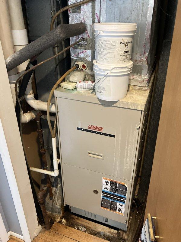 Completed on-site evaluation of 20-year-old Lennox furnace located in utility closet for replacement estimate. Unit currently operational with no reported symptoms or functional issues. Documented existing installation including vertical furnace configuration, copper refrigerant lines with foam insulation, PVC condensate drainage, and ductwork within confined mechanical space. Photographed equipment specifications, clearances, and surrounding infrastructure to provide accurate replacement recommendations and ensure proper sizing for new system installation.