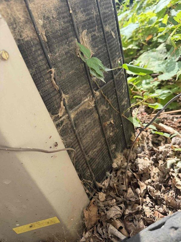 Responded to service call for 16-year-old air conditioning unit experiencing operational issues. Upon inspection, found condenser coil heavily contaminated with dirt, dust, debris, and organic material buildup, significantly restricting airflow and reducing system efficiency. Flexible ductwork showed visible wear and deterioration with vegetation encroachment around unit perimeter. Documented equipment condition with photographs showing extensive debris accumulation on condenser fins and neglected maintenance state. Appointment rescheduled for comprehensive system evaluation and necessary repairs.