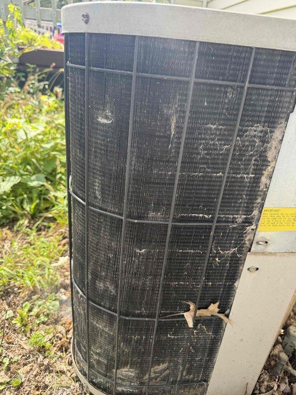 Responded to service call for 16-year-old air conditioning unit experiencing operational issues. Upon inspection, found condenser coil heavily contaminated with dirt, dust, debris, and organic material buildup, significantly restricting airflow and reducing system efficiency. Flexible ductwork showed visible wear and deterioration with vegetation encroachment around unit perimeter. Documented equipment condition with photographs showing extensive debris accumulation on condenser fins and neglected maintenance state. Appointment rescheduled for comprehensive system evaluation and necessary repairs.
