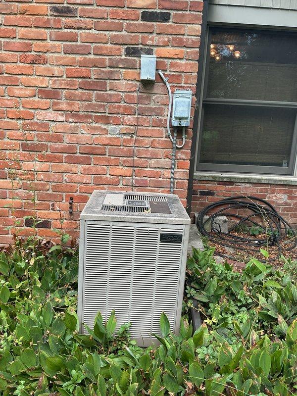 Provided comprehensive replacement estimate for 40+ year old residential air conditioning system currently operational but nearing end of service life. Evaluated existing outdoor condenser unit positioned on concrete pad against brick exterior, assessed indoor furnace and evaporator coil configuration located in dedicated equipment room with outside-only access, and confirmed natural gas fuel source for heating system. Documented equipment specifications, measured installation space constraints, verified electrical service capacity, and photographed current system layout to develop accurate replacement proposal for complete HVAC system upgrade.