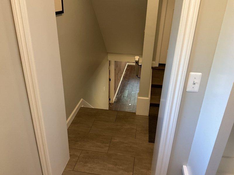 Responded to water leak in basement where carpet had been previously removed. Inspected affected area and flooring, documented damage to wood-look tile flooring and surrounding surfaces. Marked and assessed compromised flooring sections to determine extent of water intrusion and necessary remediation.