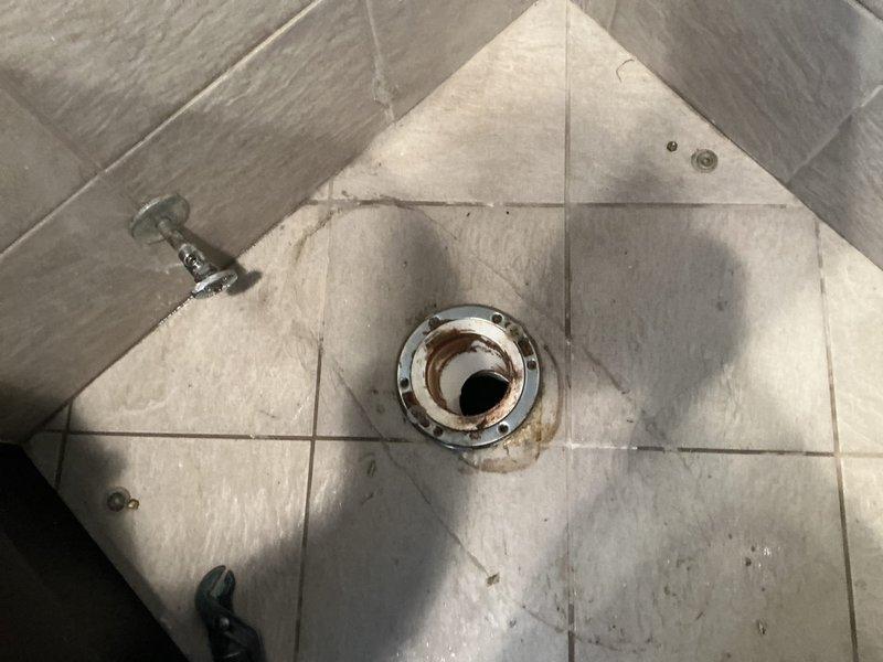 Responded to report of water leak from ceiling suspected to originate from upstairs bathroom. Upon investigation, accessed ceiling cavity and identified source of moisture intrusion related to plumbing fixture above. Inspected upstairs bathroom shower area and drain assembly, noting significant rust and corrosion on drain fixture and evidence of water damage on tile surfaces. Documented conditions via photography for assessment and provided recommendations for necessary repairs to resolve leak and prevent further ceiling damage.