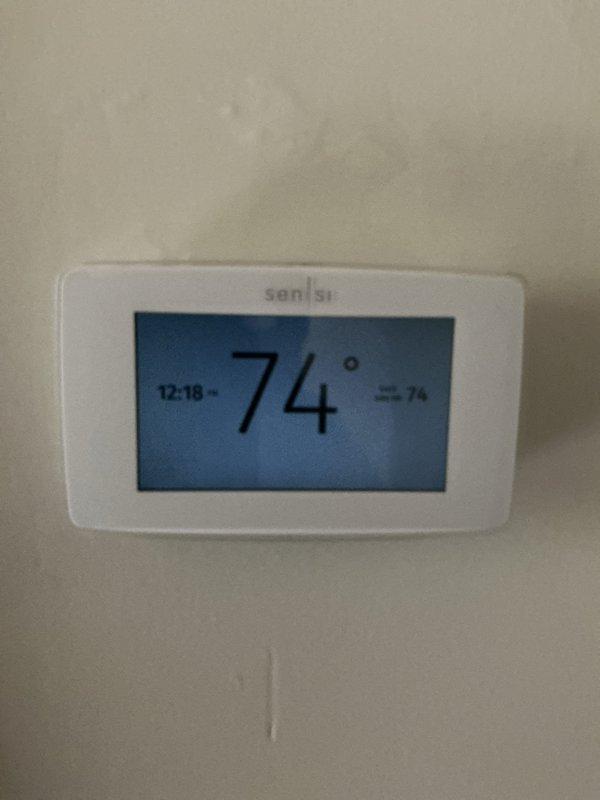 Completed comprehensive Gold AC Inspection on an 8-year-old residential air conditioning system with air handler located in basement utility room. System was operational at time of inspection with thermostat displaying 74°F and functioning properly. Performed standard maintenance procedures including visual inspection of equipment, verification of proper refrigerant levels, assessment of electrical connections, examination of condensate drainage system, and evaluation of overall system performance and efficiency.