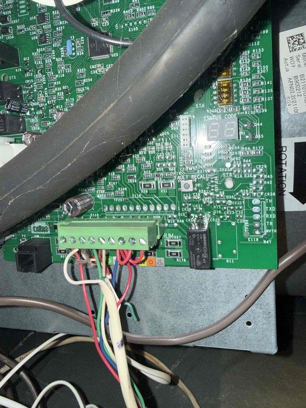 Completed Gold AC inspection on 20+ year old residential air conditioning system located in basement. Upon examination, discovered significant evaporator coil icing with temperature reading of 54°F at the air handler, indicating restricted airflow or potential refrigerant issue. Inspected control board wiring and electrical connections, which appeared intact with proper terminations at terminal block. System was operational at time of inspection despite ice buildup on coil surfaces. Documented conditions with photographic evidence of frosted evaporator coil and control board components for maintenance records.