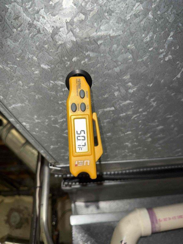 Completed Gold AC inspection on 20+ year old residential air conditioning system located in basement. Upon examination, discovered significant evaporator coil icing with temperature reading of 54°F at the air handler, indicating restricted airflow or potential refrigerant issue. Inspected control board wiring and electrical connections, which appeared intact with proper terminations at terminal block. System was operational at time of inspection despite ice buildup on coil surfaces. Documented conditions with photographic evidence of frosted evaporator coil and control board components for maintenance records.