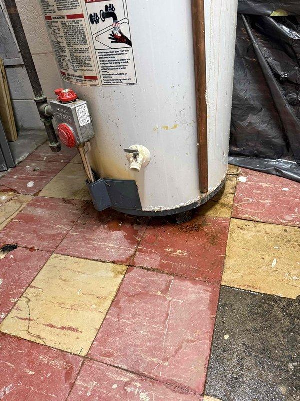 Responded to service call for reported leaking and condensation at the base of residential water heater. Upon inspection, observed moisture accumulation on lower portion of unit with visible staining and discoloration on tank exterior. Examined gas control valve assembly, temperature/pressure relief valve, drain valve, and all water connections for signs of active leakage. Inspected copper supply lines and fittings at top of unit for potential drips traveling down exterior. Assessed condensation patterns and environmental conditions in utility room. Documented current condition of water heater including age-related wear, floor tile damage from moisture exposure, and overall installation setup. Provided recommendations for addressing moisture issue and discussed repair or replacement options with homeowner based on unit condition and severity of leak source.