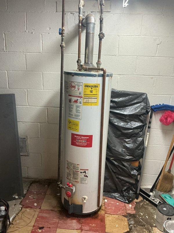 Responded to service call for reported leaking and condensation at the base of residential water heater. Upon inspection, observed moisture accumulation on lower portion of unit with visible staining and discoloration on tank exterior. Examined gas control valve assembly, temperature/pressure relief valve, drain valve, and all water connections for signs of active leakage. Inspected copper supply lines and fittings at top of unit for potential drips traveling down exterior. Assessed condensation patterns and environmental conditions in utility room. Documented current condition of water heater including age-related wear, floor tile damage from moisture exposure, and overall installation setup. Provided recommendations for addressing moisture issue and discussed repair or replacement options with homeowner based on unit condition and severity of leak source.