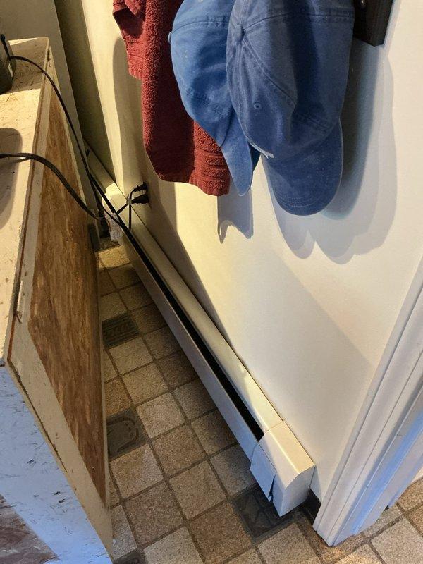 Performed site assessment for conversion of existing electric baseboard heating system to hot water radiator distribution. Evaluated current 40-year-old hot water boiler located in basement for compatibility with proposed cast iron radiator installation. Documented existing baseboard heater locations and conditions in multiple rooms to determine radiator placement requirements and piping modifications needed for system conversion.