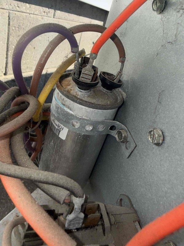 Responded to no-cooling complaint at rental property where tenant reported unusual fan noise and complete loss of cooling capacity. Upon inspection, identified failed run capacitor with severe corrosion and oxidation on terminals. Replaced defective capacitor with new unit, verified all electrical connections, and tested system operation. Unit now running properly with normal fan operation and adequate cooling restored.