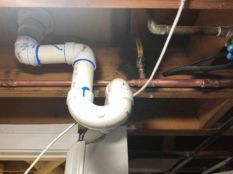 Responded to a water leak in the basement. Upon inspection, identified leaking at the P-trap assembly beneath a sink fixture. Replaced the deteriorated white PVC P-trap and associated drain connections. Verified proper seal at all connection points, tested the drain system for leaks, and confirmed the repair eliminated the water intrusion issue.